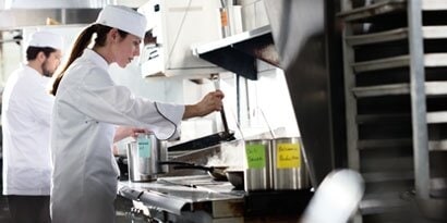 Dos chefs cocinando en una cocina.
