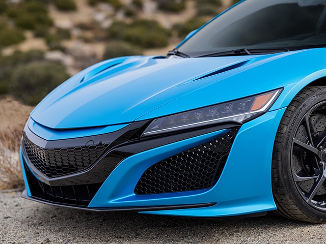 Close-up de la zona delantera del cofre de un auto deportivo con vinilo decorativo color azul brillo oceánico.
