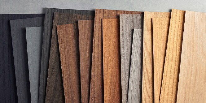 Imagen de muestras de grano de madera 3M DINOC organizadas desde tonos oscuros hasta tonos de madera clara.
