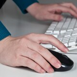 Man in warehouse doing online medical evaluations on a laptop