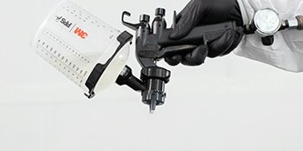 Técnico de pintura pulverizando vehículo.
