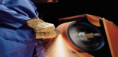 Application Image of metalworker grinding using a 3M Cubitron II belt
