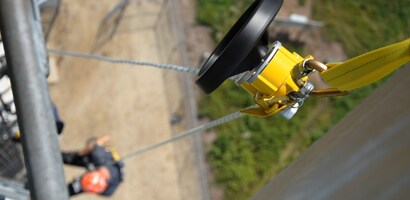 Worker suspended from controlled descent device
