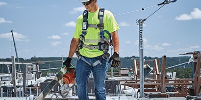 Man clmbing ladder wearing 3M DBI-SALA Permanent Lifeline System
