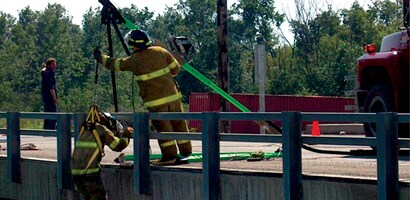 Rescue workers operating vertical confined space davit
