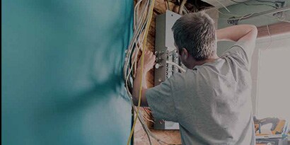 Imagen de la aplicación de Temflex de un electricista que trabaja en una caja de conexiones residencial

