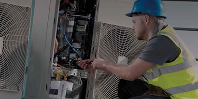 Imagen de un electricista aplicando Scotch en una caja de conexiones comercial
