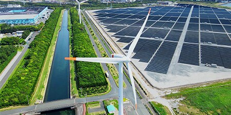 Aerogenerador y paneles solares en un campo.
