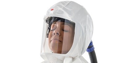 Mujer viste un casco de PAPR de 3M

