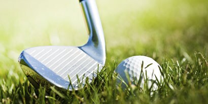 Golf club striking golf ball