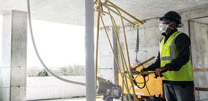 Un hombre en un sitio de construcción lleva equipo de protección personal (EPP)
