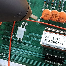 Hot melt adhesive is applied to an electrical circuit board