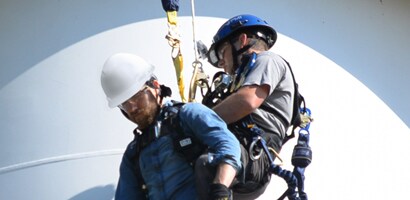 Worker rescuing co-worker at height with controlled ascent device

